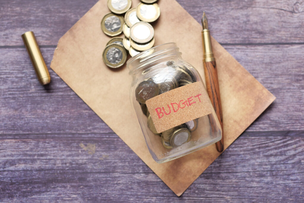 Jar of coins laid out on a table with a fancy pen